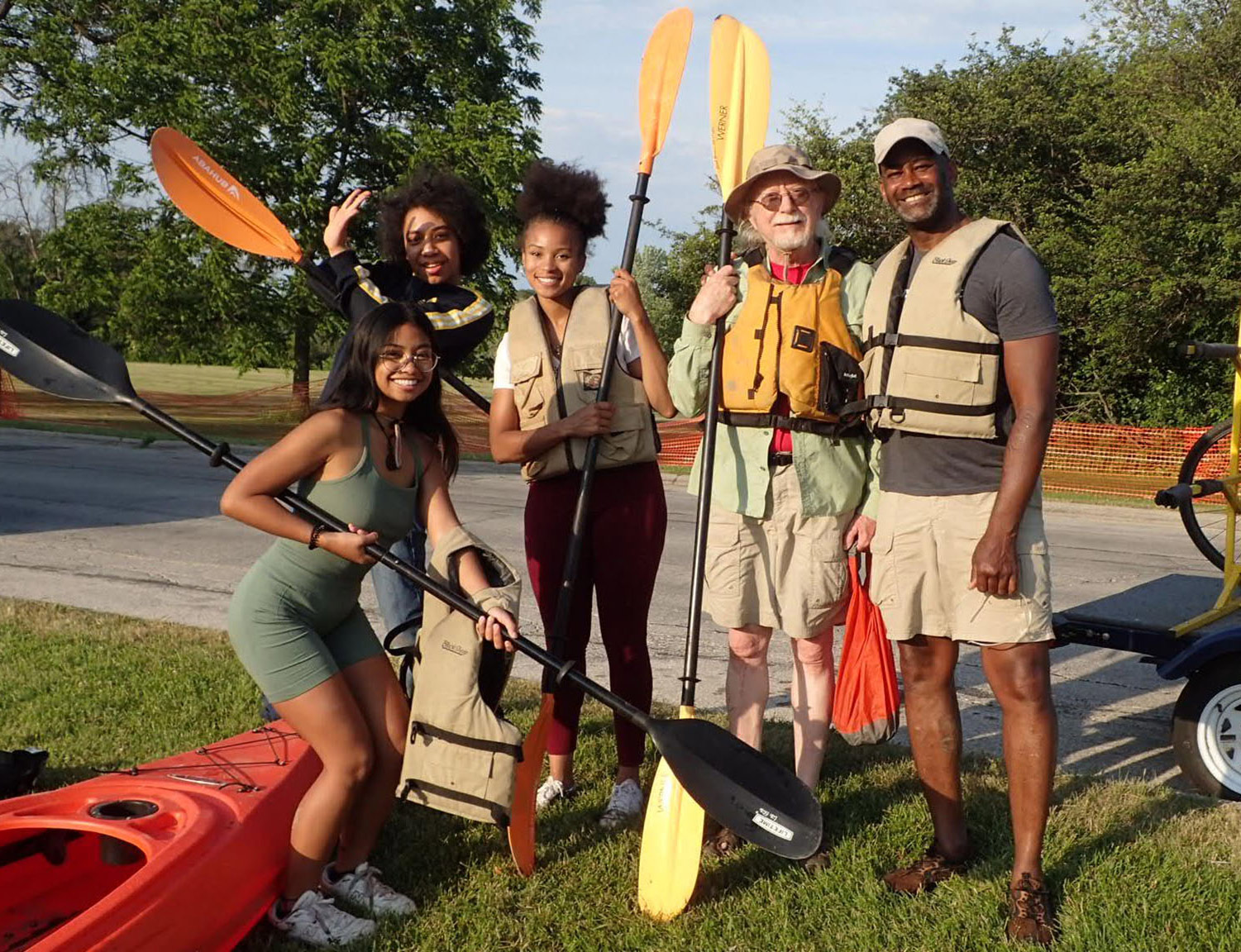 A group of people holding kayak paddles